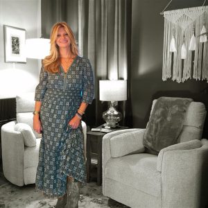 Angela in blue dress, stylish interior.